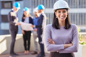 Happy woman, portrait and architect with arms crossed for construction in team management or leadership on site. Confident female person, engineer or manager with hard hat for industrial architecture.
